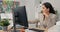 An attractive, experienced company accountant sits in office in front of a computer checking statistical data employee