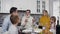 Attractive family of man,woman and their children with respected grandfather sitting at the Thanksgiving table and