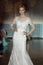 Attractive fashion model in wedding dress on stage in spotlight.