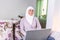 Attractive female Arabic working on laptop computer and paperwork`s on desk. Muslim Businesswoman working at home. Dedication and