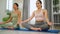 Attractive female coach teach people in the yoga class. People practicing lesson with instructor. Exercise and stretching healthy