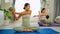 Attractive female coach teach people in the yoga class. People practicing lesson with instructor. Exercise and stretching healthy