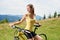 Attractive female cyclist with yellow mountain bicycle, enjoying sunny day in the mountains