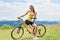 Attractive female cyclist with yellow mountain bicycle, enjoying sunny day in the mountains