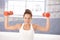 Attractive female exercising with dumbbells