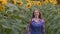 Attractive, female farmer running through a sunflower field