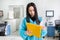 Attractive female lab worker making medical research in modern laboratory. Scientist holding documents folder with