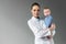 attractive female pediatrician holding beautiful little baby