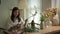 Attractive female small business owner cutting stems of pink flower at her floral shop. Small business and floristry