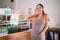 attractive female stall owner wearing apron showing thumbs up