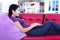 Attractive female typing at home on red sofa