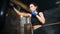 Attractive fit boxer woman with perfect slim body hitting punching bag at dark gym interior