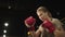 Attractive fit girl boxing in fitness center. Sport woman doing punches at gym