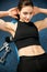 Attractive fit woamn working out abs in fitness gym, making ab i