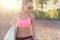 Attractive fit woman in sportswear training outdoors, female athlete with perfect body resting after workout, fashion