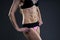 Attractive fitness woman on gray background in studio. Muscular abdomen close-up