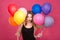 Attractive flirty woman with colorful balloons planning surprise