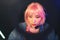 attractive focused Asian female hipster in headphones and pink wig copy space video games concept medium closeup