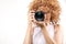 Attractive frizzy-haired lady taking a photograph