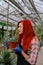 Attractive gardener lady with love analyzing the decorative plant while holding a pot she looking straight to the plant