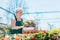 Attractive gardener selecting flowers in a gardening center.