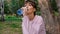 Attractive girl blonde drinking water with pleasure outdoors. A young woman is drinking clean water from a plastic