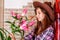 Attractive girl in a cowboy hat with straight long hair holds lily flowers