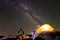 Attractive girl doing gymnastic exercises on big boulder on dark blue starry evening sky