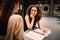 Attractive girl happily talking with friend waiting washing in self-service laundry