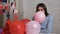 Attractive girl inflates balloons for Valentine`s Day