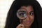 Attractive girl looking through magnifier, smiling