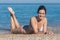 Attractive girl lying on pebble at waters edge