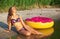 Attractive girl lying on the seashore with inflatable donut. Rest on the beach