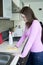 Attractive girl polishing tabletop on the kitchen