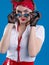 An attractive girl with a red bandana on her head attentively looks with lowered glasses. Girl in pin-up style isolated on blue ba