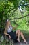 Attractive girl sitting on the wood and smelling flowers