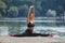 Attractive girl in sportswear does gymnastic exercises on a wooden pier in a city park