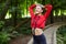 Attractive girl in sportswear is doing gymnastic exercises on the track in the forest park