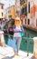 Attractive girl on the waterfront of a narrow canal in Venice