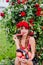 Attractive girl with a wreath of red roses with a basket of vegetables: tomatoes, eggplants, peppers