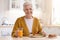 Attractive grandmother smiling at camera, having lunch in kitchen
