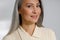 Attractive grey haired mature lady in stylish shirt smiles to camera in studio