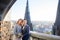 Attractive groom and bride in grey jacket stand on the balcony