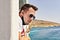 Attractive guy in sunglasses and face mask less enjoys of fresh sea breeze sea ferry in Mediterranean sea