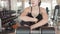 Attractive happiness sport woman resting and relaxing on fitness gym bench and smiling. People lifestyle and healthy activity and