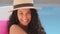 Attractive happy millennial Hispanic girl in summer hat enjoying vacation. Closeup headshot young woman smiling