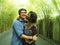 Attractive and happy mixed ethnicity couple cuddling outdoors with attractive black afro American girlfriend or wife and handsome