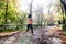 Attractive and happy runner woman in Autumn sportswear running and training on jogging outdoors workout in city park