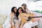 Attractive happy women of different ethnics with guitar have fun together inside the camper van