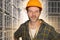 Attractive and happy workman in safety helmet smiling confident posing relaxed as successful contractor or handyman at warehouse